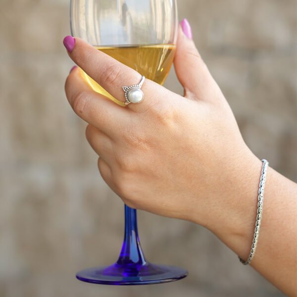 hands holding glass wearing silver ring