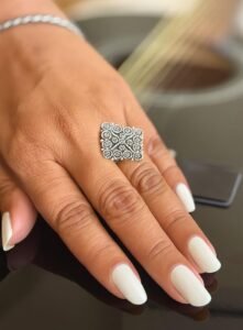 Square silver ring with a filigree design.